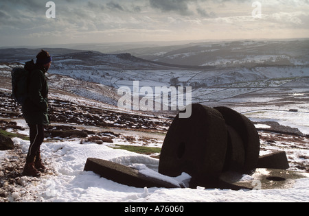 Inverno Walker nella neve e macine abbandonate al di sotto di "Bordo tanage' nel Derbyshire "Gran Bretagna" Foto Stock
