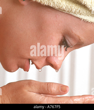 Giovane donna faccia di lavaggio closeup Foto Stock