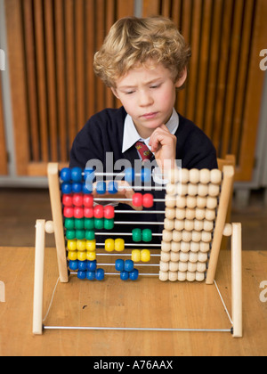 Ragazzo (4-7) utilizzando abacus, close-up Foto Stock