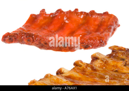 Rack di marinaded BBQ e nervature cinese coperti in salsa su un puro sfondo bianco. Foto Stock