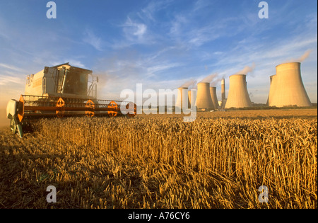 Una mietitrebbia il raccolto di un raccolto di grano con Ratcliffe sulle aspre Coal Fired power station dietro. Foto Stock