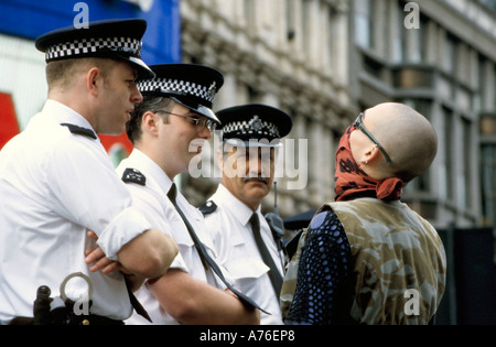 Tre poliziotti parlando a un skinhead dimostrante durante il giorno di maggio dimostrazioni. Foto Stock