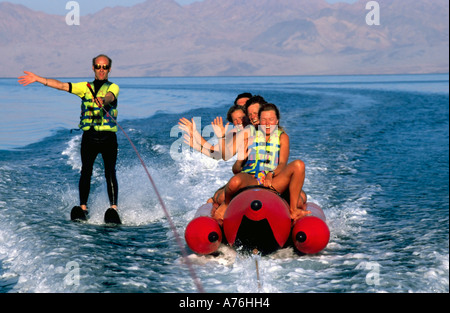 Sciatore acqua e banana boat piloti (turisti) agitando e divertirsi sul mare. Foto Stock