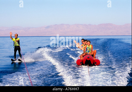 Sciatore acqua e banana boat piloti (turisti) agitando e divertirsi sul mare. Foto Stock