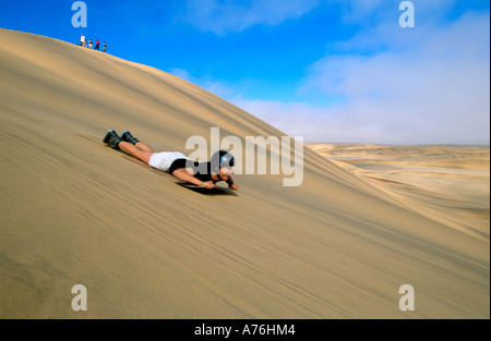 Un boarder di sabbia la discesa delle dune di sabbia della Namibia. Foto Stock