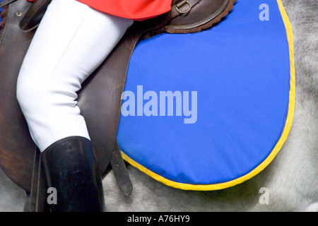 Close up della sella e numnah su un cavallo e tradizionalmente condita rider alle gare. Foto Stock