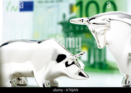 Bull e bear statuetta, di banconote in euro in background, close-up Foto Stock