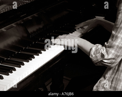 Vista dettagliata del pianista femmina in prove di mani sta giocando attivamente la tastiera del pianoforte Foto Stock