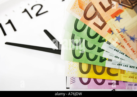 Le banconote in euro e orologio, simbolo per il tempo è denaro Foto Stock