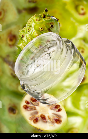 Il Noni cosmetici, frutta fresca in background, close-up Foto Stock