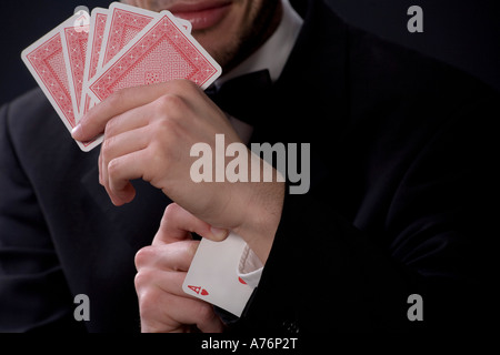 Uomo con carte da gioco, ace nel manicotto Foto Stock