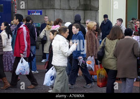 La gente camminare passato uno su persone mobili tramite bancomat mentre fuori lo shopping natalizio a Belfast per la Vigilia di Natale Foto Stock