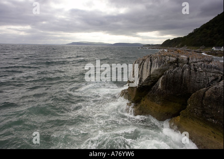Onde infrangersi sulle rocce al punto garron County Antrim Irlanda del Nord Foto Stock