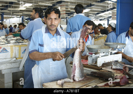 L'uomo la sfilettatura pesce al mercato in Deira Dubai Foto Stock