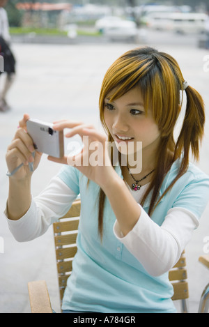 Ragazza adolescente utilizzando una fotocamera digitale Foto Stock