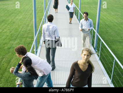 Persone in piedi e camminando sul marciapiede Foto Stock