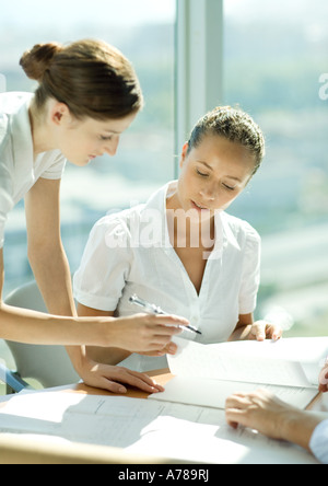 Due donne a discutere insieme di documenti Foto Stock