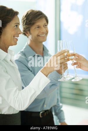 I professionisti maturi la tostatura con bicchieri di champagne Foto Stock