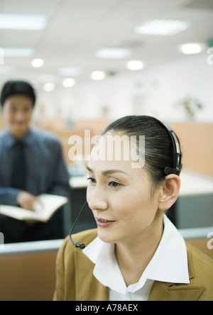 Imprenditrice che indossa la cuffia in office Foto Stock