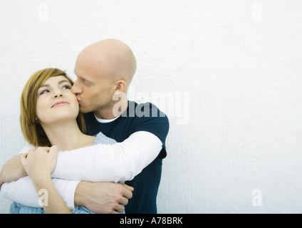 Coppia giovane, uomo donna baciando la guancia donna da dietro Foto Stock