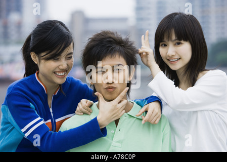 Tre giovani amici adulti tenendo giocoso pone Foto Stock