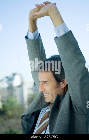 Imprenditore stretching le braccia sopra la testa Foto Stock