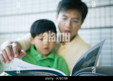 Padre e figlio guardando il libro insieme Foto Stock