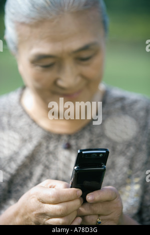 Senior donna la composizione del numero di telefono cellulare Foto Stock