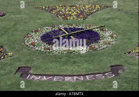 Orologio floreale in aiuole di fiori sul terrapieno di erba accanto a Inverness Castle completare con segno di Inverness Foto Stock