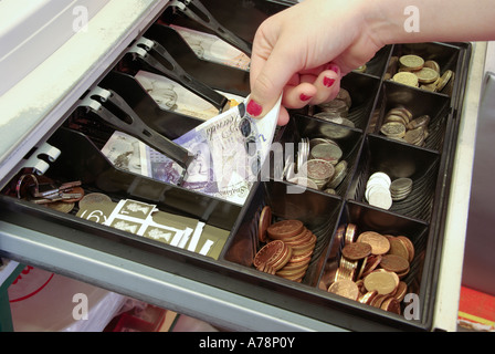 Open shop fino concept immagine MR modello rilasciato mano donna nel commercio al dettaglio fino a rimuovere £20 monete di nota della libbra venti & altri legale Tender Inghilterra UK Foto Stock