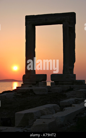 Arco del tempio di Apollo al tramonto con il sole che riflette dall'acqua calma in background la città di Naxos Naxos Grecia Foto Stock