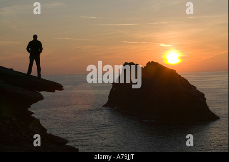 Un uomo su le cime della scogliera che si affaccia Meachard isola Boscastle al tramonto, Cornwall, Regno Unito Foto Stock