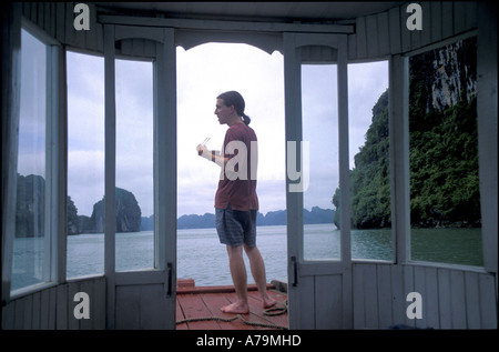 Tourist con bacchette sulla prua della barca nella Baia di Ha Long Golfo del Tonchino Vietnam del nord n. MR Foto Stock