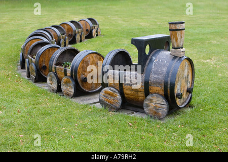 Riutilizzato giocattolo di legno treno motore & carrelli; Giardino mobili realizzati da botti di whisky a Speyside Cooperage Dufftown, Scotland Regno Unito Foto Stock