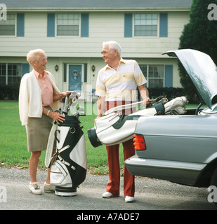 Coppia matura il caricamento di mazze da golf nel baule auto Foto Stock