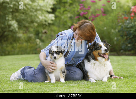 Donna con pastore australiano e cucciolo Foto Stock