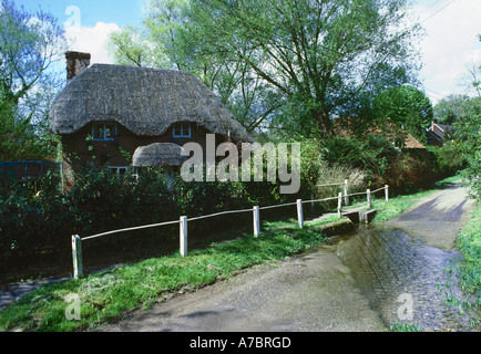 Cottage con il tetto di paglia da una Ford nel grazioso villaggio di Nether Wallop in Hampshire Foto Stock