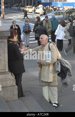 Hari Krishna devoto passando dalla letteratura nella parte anteriore della Biblioteca Pubblica di New York a 42nd St e 5th Avenue a Manhattan Foto Stock