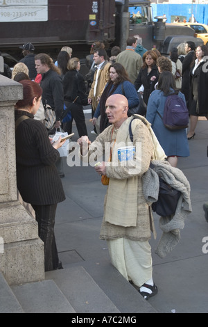 Hari Krishna devoto passando dalla letteratura nella parte anteriore della Biblioteca Pubblica di New York a 42nd St e 5th Avenue a Manhattan Foto Stock