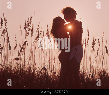 Coppia romantica abbracciando in patch di mare di avena in spiaggia Foto Stock