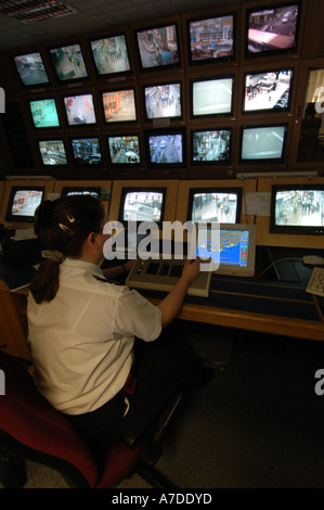 Un operatore TVCC a Brighton stazione di polizia controlla una banca di schermi da telecamere CCTV monitoring per le strade della città Foto Stock