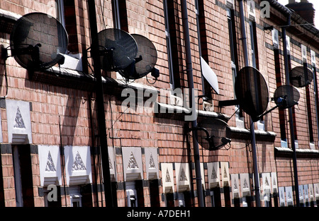 La BSkyB parabole satellitari clustered su case a schiera in una strada laterale in Evington Leicester Foto Stock