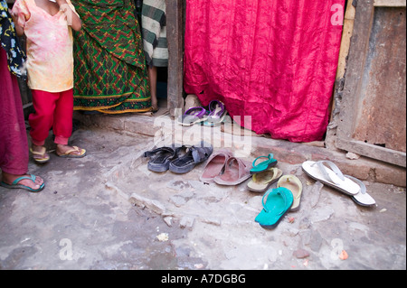 Scarpe a sinistra fuori dall'entrata di questa casa a Dacca in Bangladesh Foto Stock