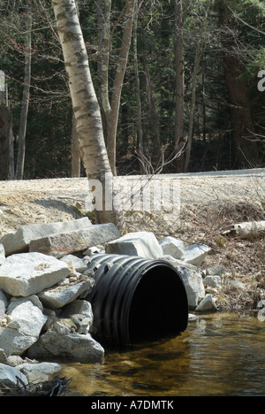 Tubo di drenaggio che consente il flusso di acqua al di sotto di una strada sterrata in Nuova Inghilterra USA Foto Stock