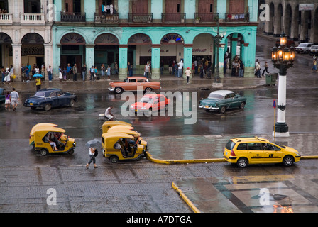 Cuba, La Habana street scene - Traffico in un giorno di pioggia vicino al El edificio Capitalio Foto Stock