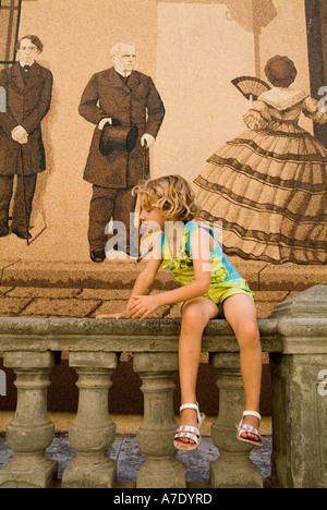 Poco ragazza seduta su una balaustra, Havana, Cuba. Foto Stock