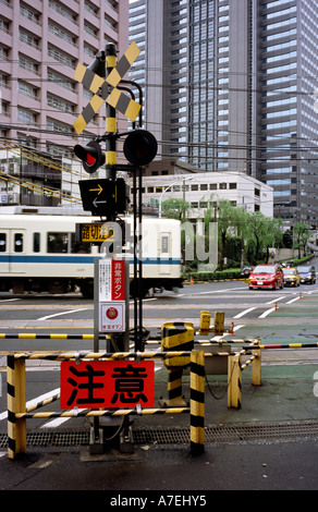 Oct 31, 2004 - treni pendolari attraversare una strada prima di entrare nella stazione di Shinjuku a Tokyo centrale. Foto Stock