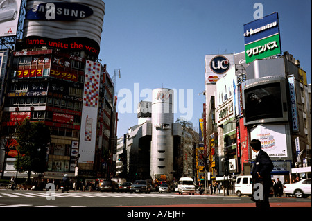 Uomo in una tuta in attesa per il traffico per cancellare in Tokyo's Shibuya e su ciò che è riferito al mondo scramble più trafficato incrocio. Foto Stock