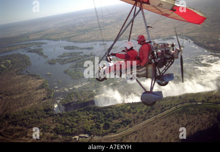 Turismo in tandem e pilota di volare in un microlite oltre il fiume Zambesi e le cascate Vittoria mosi oa tunya Zimbabwe e Zambia africa Foto Stock