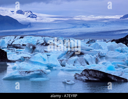 Iceberg nel lago glaciale Joekulsarlon e sullo sfondo il ghiacciaio Vatnajoekull, Islanda Foto Stock